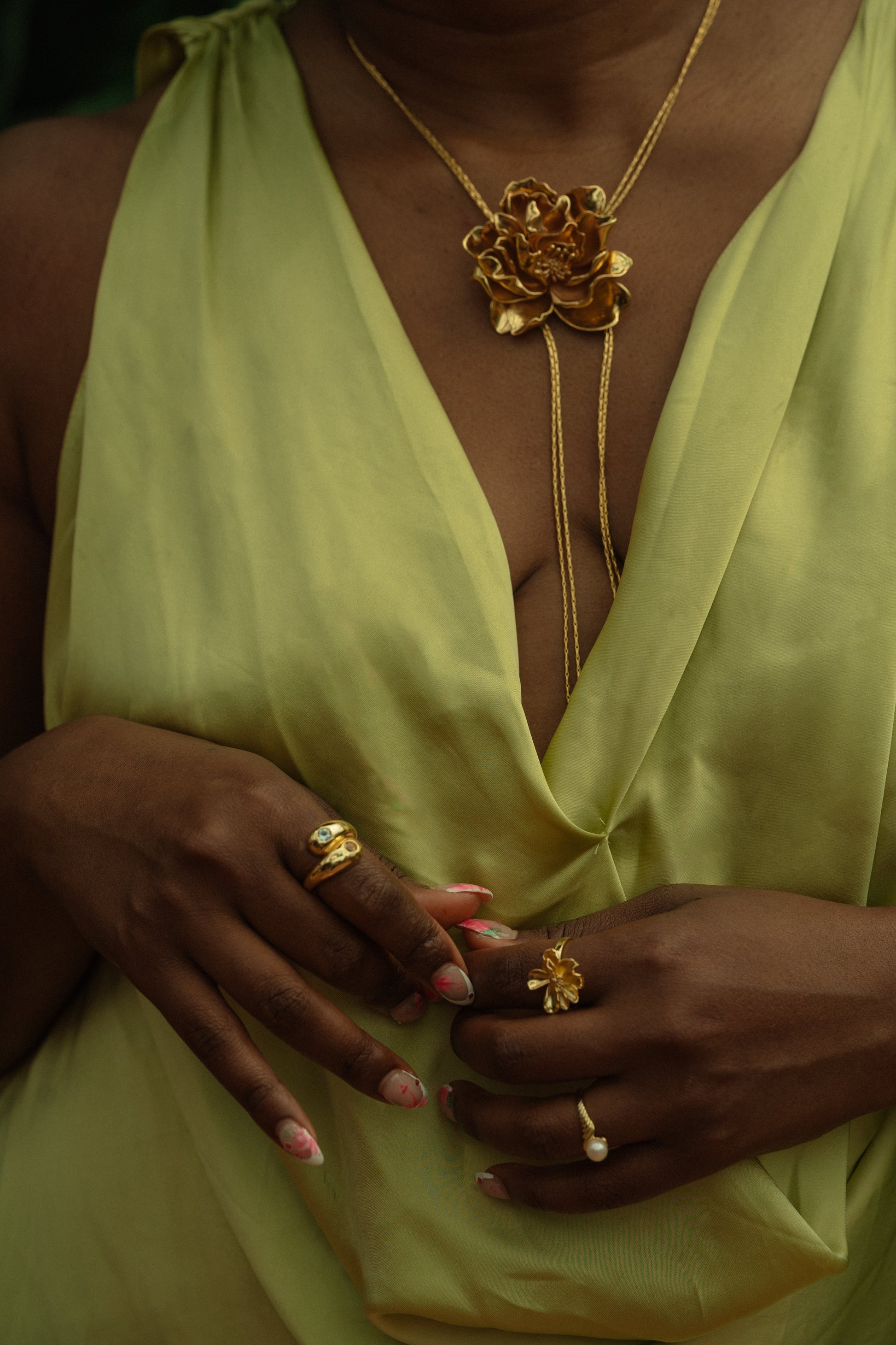 Bayahíbe Bloom Lariat Necklace with gold Rosa de Bayahíbe pendant on bamboo chain, worn with matching rings.