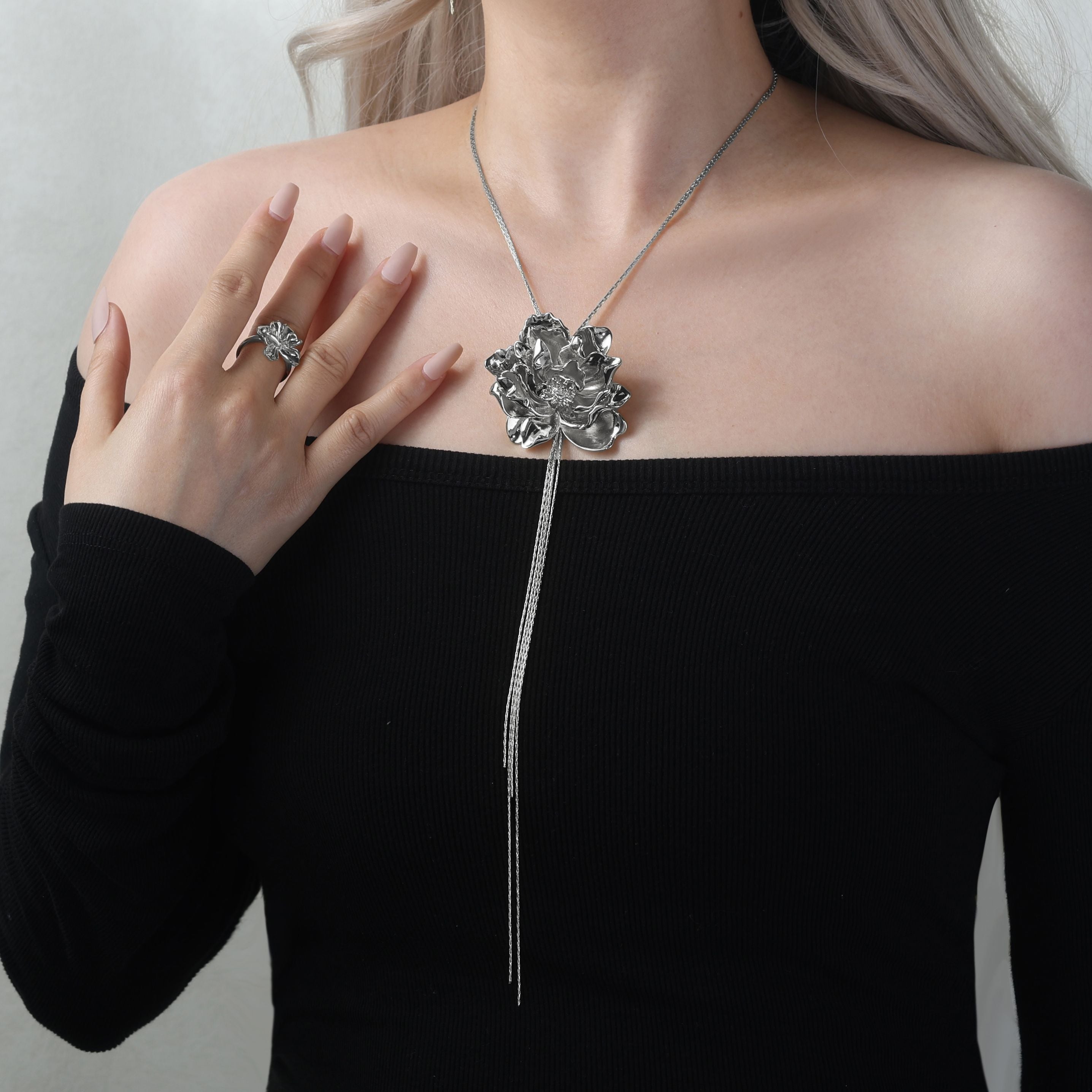 Bayahíbe Bloom Lariat Necklace featuring Rosa de Bayahíbe pendant on a round bamboo chain, worn by a model in black attire.